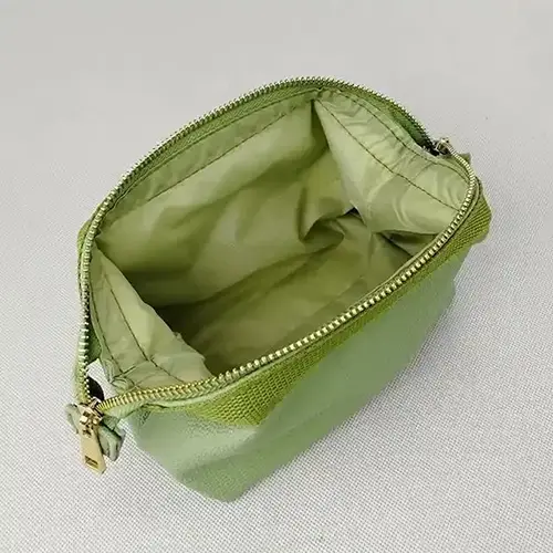 Spacious interior of a green beauty bag showing durable silk lining for cosmetic storage.